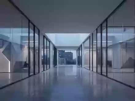 Ein minimalistischer, moderner Büroflur mit Glaswänden und reflektierenden Böden in der Abenddämmerung. - Foto: über boerse-global.de