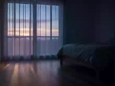 Ein minimalistisch eingerichtetes, in blaues Dämmerlicht getauchtes Schlafzimmer kurz vor Sonnenaufgang. - Foto: über boerse-global.de