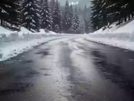 Verschneite Bergstraße mit winterlichen Fahrbahnverhältnissen in einer alpinen Landschaft. - Foto: über boerse-global.de