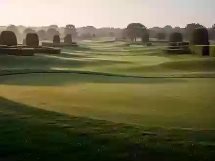 Weitläufige, perfekt gepflegte Golfplatzlandschaft mit sattem Grün bei Sonnenaufgang. - Foto: über boerse-global.de