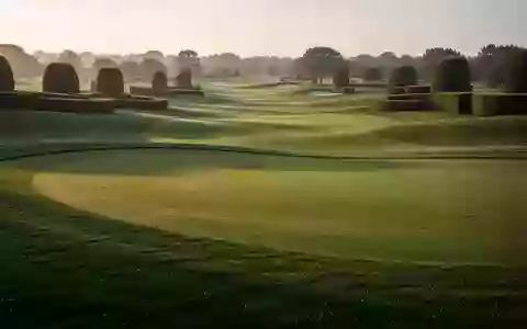 Weitläufige, perfekt gepflegte Golfplatzlandschaft mit sattem Grün bei Sonnenaufgang. - Foto: über boerse-global.de