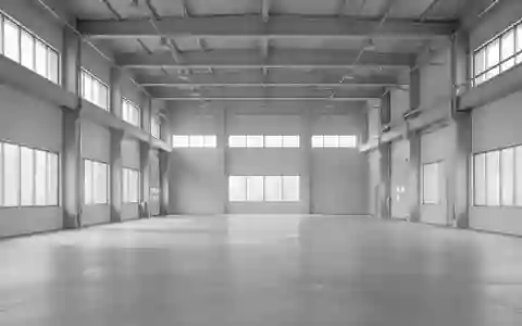 Ein minimalistisches, leeres Industriegebäude mit klaren architektonischen Linien und natürlichem Lichteinfall. - Foto: über boerse-global.de
