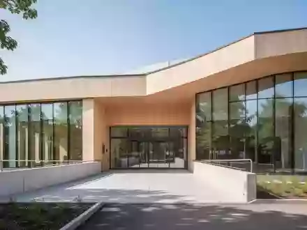 Ein modernes, barrierefreies Gesundheitshaus mit einer hellen Holzfassade und einer Rampe im Außenbereich. - Foto: über boerse-global.de