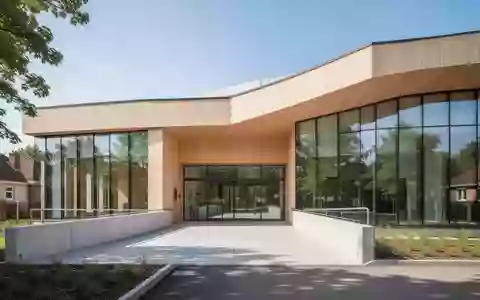 Ein modernes, barrierefreies Gesundheitshaus mit einer hellen Holzfassade und einer Rampe im Außenbereich. - Foto: über boerse-global.de