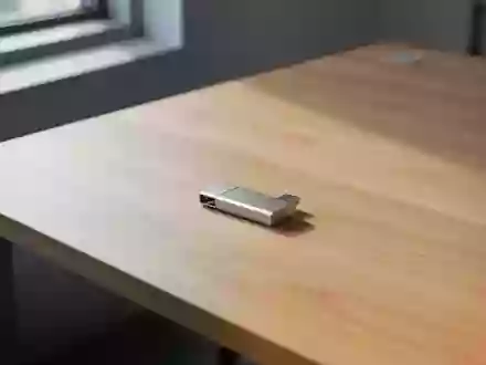Ein minimalistischer Arbeitsplatz mit einem einzelnen USB-Stick auf einer hellen Holzoberfläche bei natürlichem Licht. - Foto: über boerse-global.de