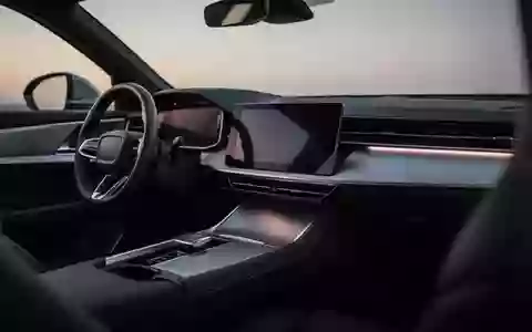 Modernes, leeres Fahrzeug-Cockpit bei Dämmerung mit einem dunklen, ausgeschalteten Infotainment-Display in einem minimalistischen Interieur. - Foto: über boerse-global.de
