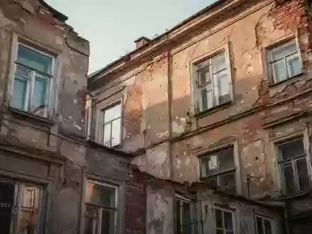 Ein sanierungsbedürftiges, älteres Wohngebäude aus Ziegelstein bei Tageslicht. - Foto: über boerse-global.de