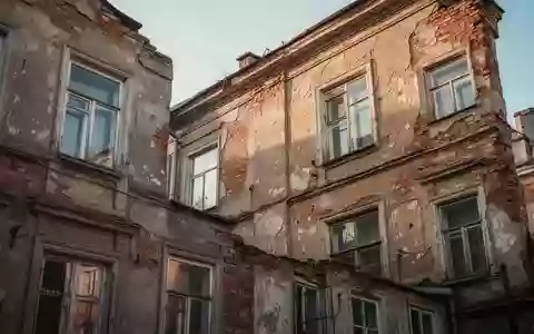 Ein sanierungsbedürftiges, älteres Wohngebäude aus Ziegelstein bei Tageslicht. - Foto: über boerse-global.de