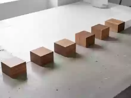 Ein minimalistischer, aufgeräumter Arbeitsplatz mit in einer logischen Reihe angeordneten Holzblöcken auf Beton. - Foto: über boerse-global.de