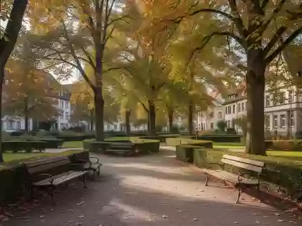 Ein ruhiger, sonniger öffentlicher Park mit leeren Holzbänken an einem gepflasterten Weg in einer Kleinstadt. - Foto: über boerse-global.de