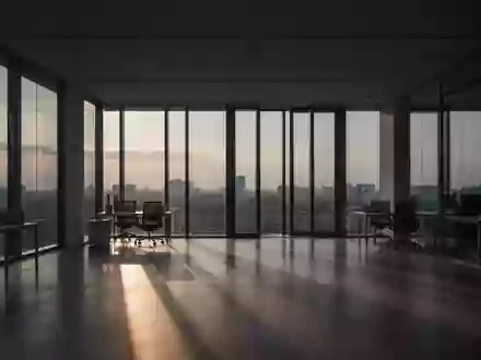 Ein leerer, minimalistischer Büroraum in der Abenddämmerung mit langen Schatten und natürlichem Licht. - Foto: über boerse-global.de