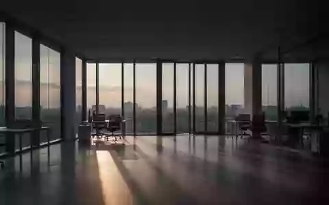 Ein leerer, minimalistischer Büroraum in der Abenddämmerung mit langen Schatten und natürlichem Licht. - Foto: über boerse-global.de