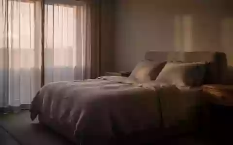 Ein ruhig gestaltetes Schlafzimmer im sanften Morgenlicht, das eine Atmosphäre der Erholung und Stille vermittelt. - Foto: über boerse-global.de