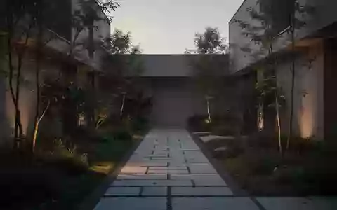 Ein ruhiger, minimalistischer Innenhof mit einem gepflasterten Pfad durch einen Garten in der Abenddämmerung. - Foto: über boerse-global.de