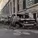 Passanten beäugen ausgebrannte Autos in Paris. - Bild: Emma Da Silva/AP/dpa