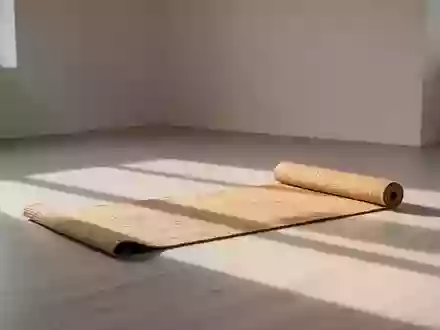 Ein heller, minimalistisch eingerichteter Raum mit einer ausgerollten Yogamatte auf einem Holzboden. - Foto: über boerse-global.de