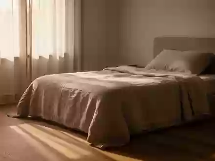 Ein sonnendurchflutetes, ruhiges Schlafzimmer am Nachmittag mit einem ordentlich gemachten Bett und weichem Licht. - Foto: über boerse-global.de