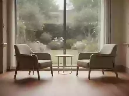 Ein minimalistischer, ruhiger Aufenthaltsraum in einer modernen Pflegeeinrichtung mit Blick in einen Garten. - Foto: über boerse-global.de