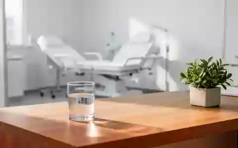 Ein heller, minimalistischer Untersuchungsraum in einer Klinik mit einer Pflanze auf einem Schreibtisch. - Foto: über boerse-global.de