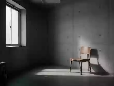 Ein minimalistischer, leerer Wartebereich in einer Klinik mit kühlem Tageslicht und einem einzelnen Stuhl. - Foto: über boerse-global.de
