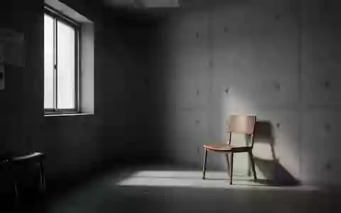 Ein minimalistischer, leerer Wartebereich in einer Klinik mit kühlem Tageslicht und einem einzelnen Stuhl. - Foto: über boerse-global.de