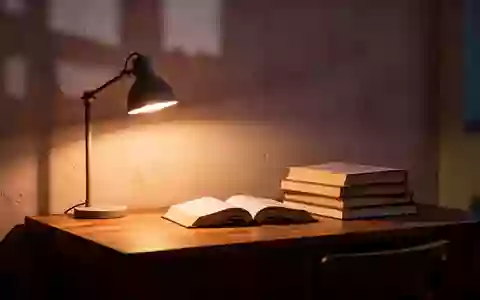 Ein ruhiger, minimalistischer Arbeitsbereich mit einem Schreibtisch, Büchern und warmem Licht, das eine nachdenkliche Atmosphäre schafft. - Foto: über boerse-global.de