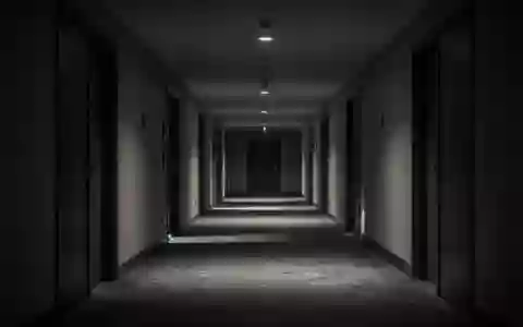 Ein leerer, schattiger Hotelkorridor mit geschlossenen Zimmertüren in gedimmtem Licht. - Foto: über boerse-global.de