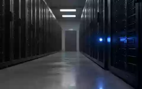 Dunkler, industrieller Serverraum mit einer einsamen blauen Statusleuchte an einem Rack vor einem verschwommenen Hintergrund. - Foto: über boerse-global.de