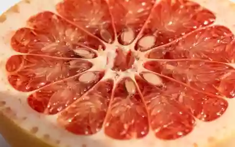 Nahaufnahme einer halbierten Grapefruit mit Fokus auf der organischen Zellstruktur und den saftigen Fruchtfleischsegmenten. - Foto: über boerse-global.de