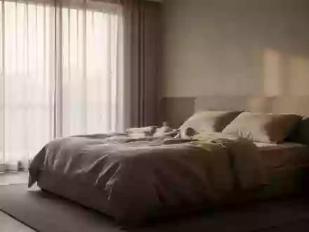 Ein minimalistisch eingerichtetes, ruhiges Schlafzimmer bei Tagesanbruch mit ungemachtem Bett und neutraler Bettwäsche. - Foto: über boerse-global.de