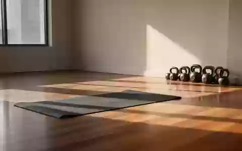 Ein minimalistischer, lichtdurchfluteter Trainingsraum mit einer Yogamatte und Kettlebells auf einem Holzboden. - Foto: über boerse-global.de
