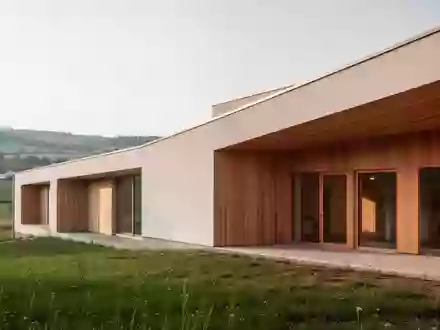 Ein modernes, architektonisch schlichtes Gebäude in einer ländlichen Umgebung, das als Pflegestützpunkt dient. - Foto: über boerse-global.de