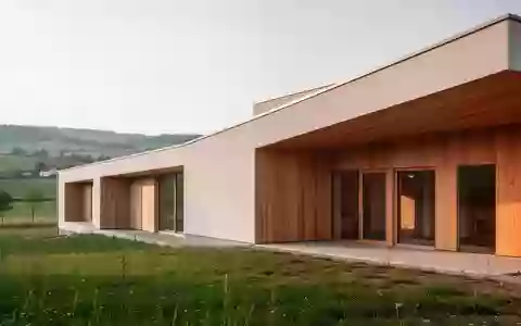 Ein modernes, architektonisch schlichtes Gebäude in einer ländlichen Umgebung, das als Pflegestützpunkt dient. - Foto: über boerse-global.de
