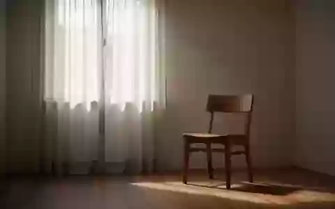 Ein ruhiger, minimalistischer Raum mit einem leeren Stuhl bei sanftem Tageslicht, der eine Atmosphäre der Erholung vermittelt. - Foto: über boerse-global.de