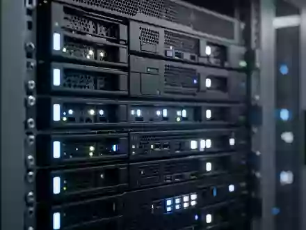 Nahaufnahme einer modernen Server-Infrastruktur mit blinkenden Statusleuchten in einem dunklen Raum. - Foto: über boerse-global.de