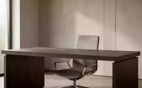 Ein minimalistisch gestalteter, aufgeräumter Arbeitsplatz mit einem dunklen Holztisch und einem ergonomischen Stuhl. - Foto: über boerse-global.de