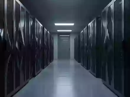 Dunkler, moderner Serverraum mit metallischen Schaltschränken in einer minimalistischen, atmosphärischen Umgebung. - Foto: über boerse-global.de