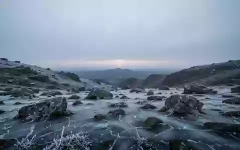Eine frostbedeckte, einsame Berglandschaft in der Dämmerung, die die Herausforderungen extremer Kälte symbolisiert. - Foto: über boerse-global.de