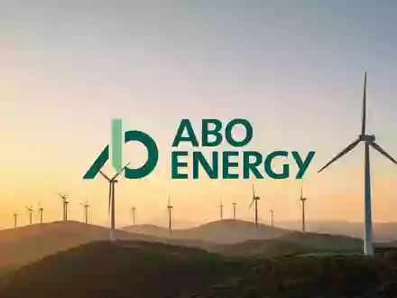 Moderne Windkraftanlagen in einer weitläufigen Landschaft bei Sonnenuntergang als Symbol für Investitionen in erneuerbare Energien. - Foto: über boerse-global.de