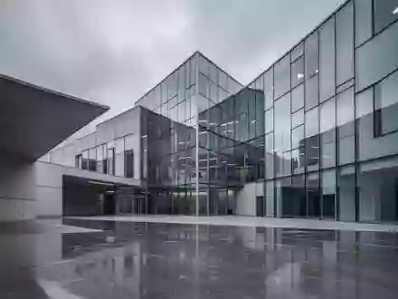 Ein modernes, minimalistisches Regierungsgebäude in Brüssel mit scharfen Glaswinkeln und polierten Betonoberflächen unter grauem Himmel. - Foto: über boerse-global.de