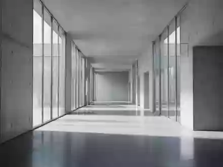 Ein minimalistischer, moderner Flur mit poliertem Betonboden und sanftem, natürlichem Lichteinfall durch Glasfronten. - Foto: über boerse-global.de