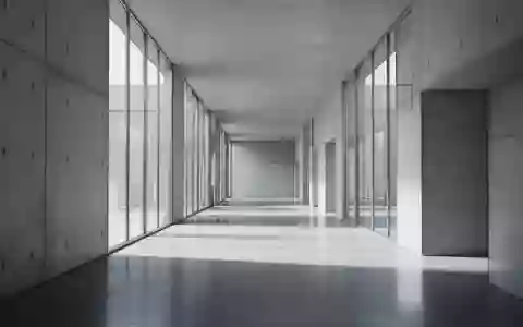 Ein minimalistischer, moderner Flur mit poliertem Betonboden und sanftem, natürlichem Lichteinfall durch Glasfronten. - Foto: über boerse-global.de