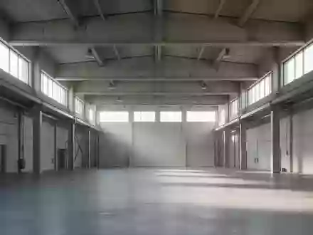 Weite, minimalistische Industriehalle mit hohen Betondecken und einfallendem Tageslicht als Symbol für den Wirtschaftsstandort. - Foto: über boerse-global.de