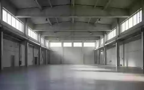Weite, minimalistische Industriehalle mit hohen Betondecken und einfallendem Tageslicht als Symbol für den Wirtschaftsstandort. - Foto: über boerse-global.de
