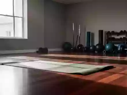 Eine leere Sportmatte auf einem polierten Holzboden in einem hellen, minimalistischen Fitnessstudio. - Foto: über boerse-global.de