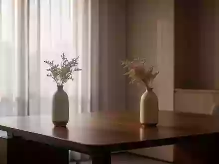 Ein minimalistischer, ruhiger Büroraum mit einem leeren Schreibtisch und einer schlichten Vase in einer ruhigen Atmosphäre. - Foto: über boerse-global.de