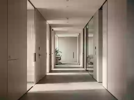 Ein minimalistischer, moderner Büroflur mit klaren architektonischen Linien und neutraler Beleuchtung. - Foto: über boerse-global.de