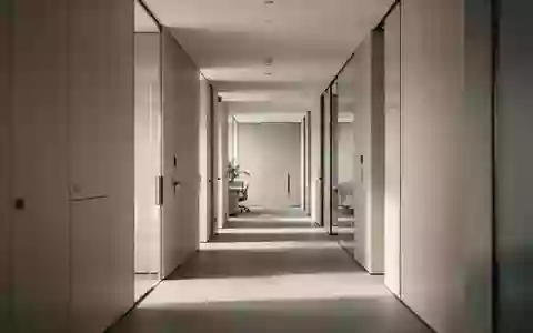 Ein minimalistischer, moderner Büroflur mit klaren architektonischen Linien und neutraler Beleuchtung. - Foto: über boerse-global.de