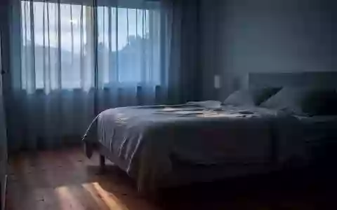 Ein ruhiges Schlafzimmer im sanften Licht der frühen Morgendämmerung mit einem unbenutzten, ordentlich gemachten Bett. - Foto: über boerse-global.de