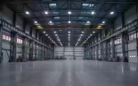 Weite, menschenleere Industriehalle einer modernen Produktionsstätte mit metallischer Architektur und klaren Linien. - Foto: über boerse-global.de